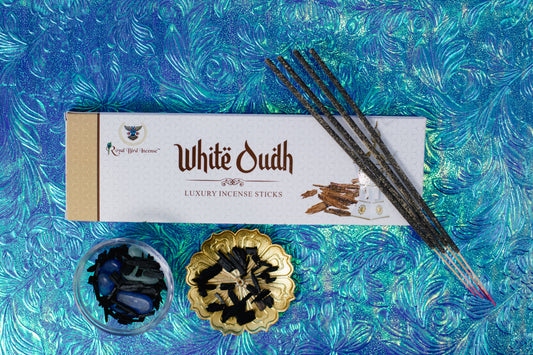 White Oudh incense sticks with packaging on a blue textured background